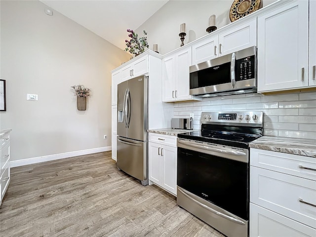 kitchen with white cabinetry, lofted ceiling, and stainless steel appliances