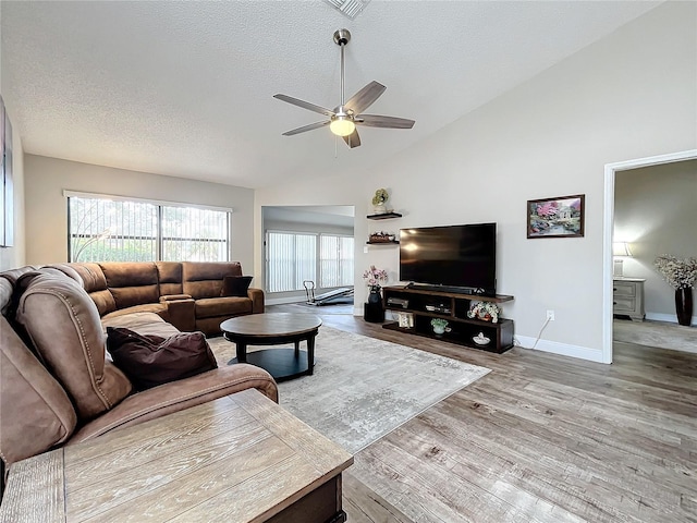 living room with light wood-type flooring, ceiling fan, a textured ceiling, and lofted ceiling