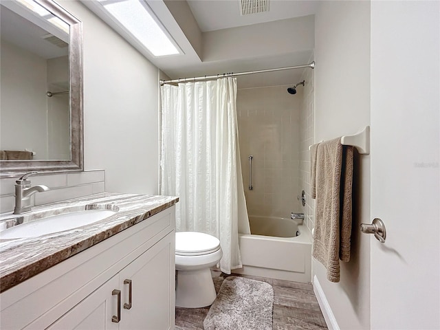 full bathroom featuring hardwood / wood-style floors, toilet, vanity, and shower / bathtub combination with curtain