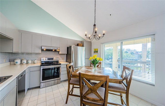 kitchen featuring pendant lighting, stainless steel appliances, decorative backsplash, a chandelier, and gray cabinetry