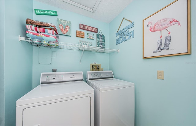 clothes washing area with a textured ceiling and washing machine and dryer