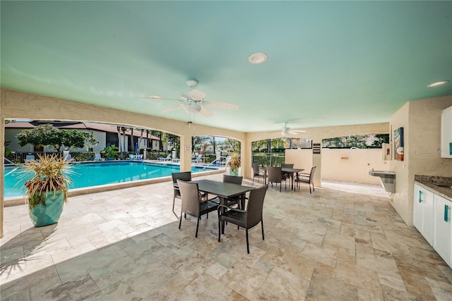 view of swimming pool with ceiling fan and a patio