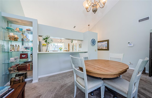 carpeted dining room featuring high vaulted ceiling and a notable chandelier