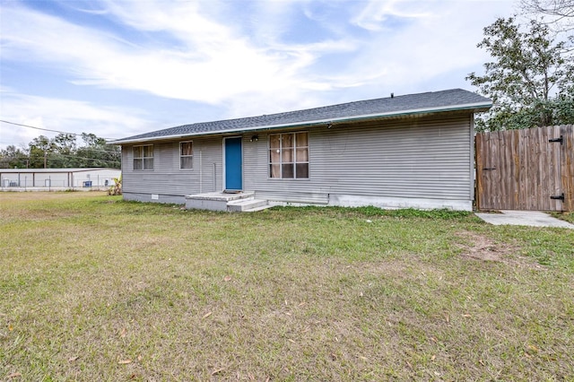 rear view of house featuring a yard