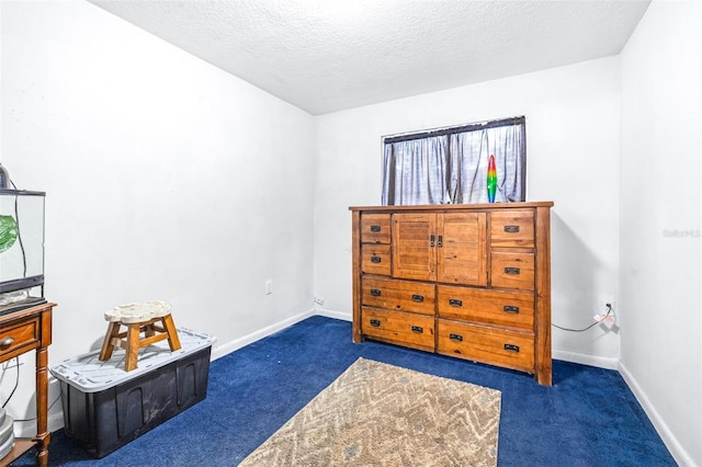 bedroom with dark carpet and a textured ceiling