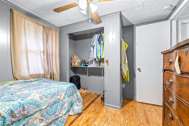 bedroom with multiple windows, a textured ceiling, ceiling fan, and light hardwood / wood-style flooring