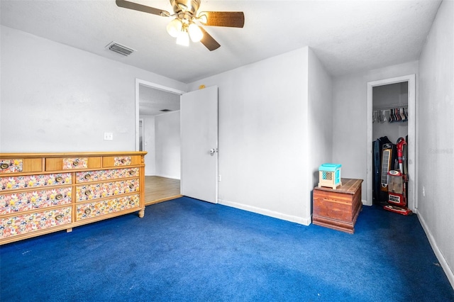 bedroom featuring a textured ceiling, ceiling fan, a closet, and dark colored carpet