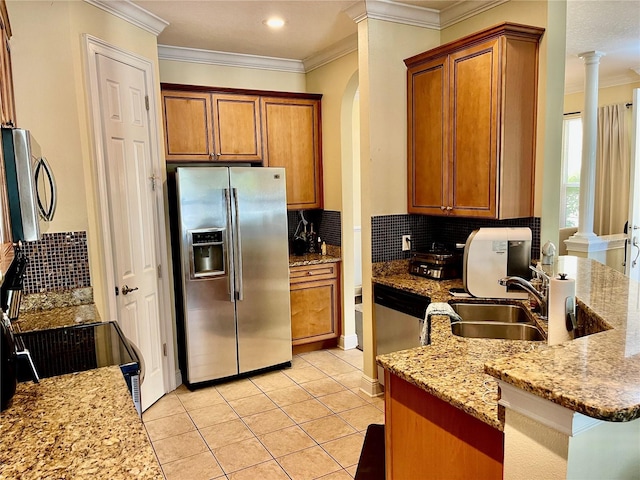 kitchen featuring crown molding, light tile patterned floors, appliances with stainless steel finishes, light stone countertops, and decorative columns