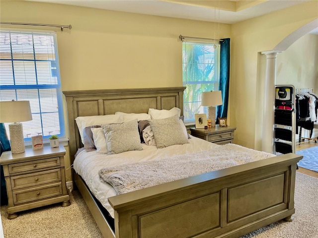 bedroom featuring multiple windows and ornate columns