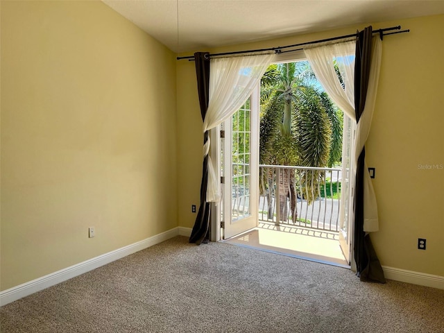 carpeted spare room featuring baseboards