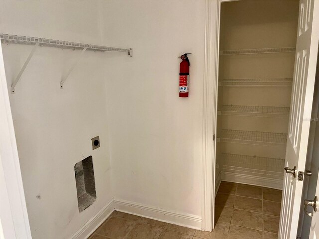 laundry room with tile patterned floors, hookup for an electric dryer, and baseboards