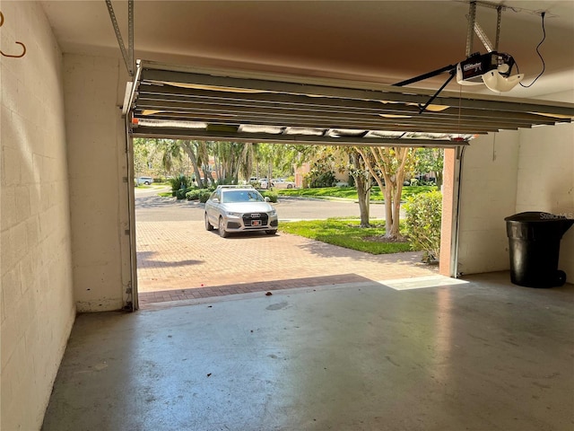 garage with concrete block wall and a garage door opener