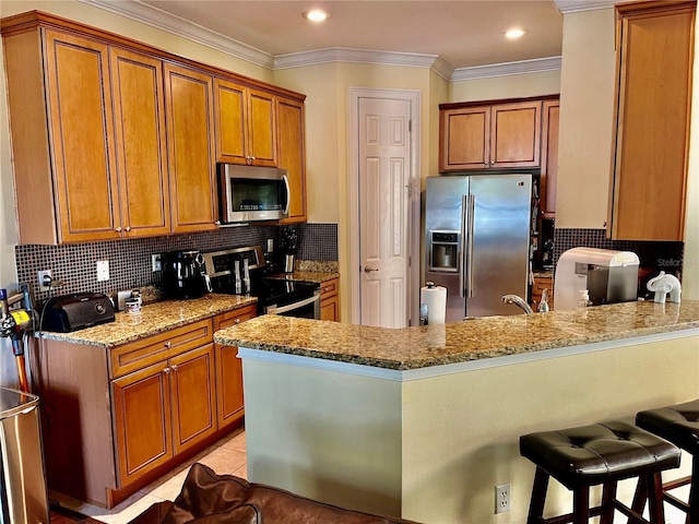 kitchen featuring a peninsula, crown molding, light stone countertops, brown cabinets, and appliances with stainless steel finishes