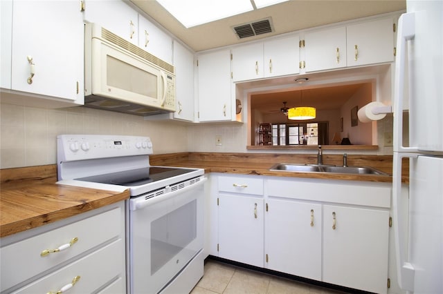 kitchen featuring sink, white cabinetry, decorative light fixtures, light tile patterned floors, and white appliances