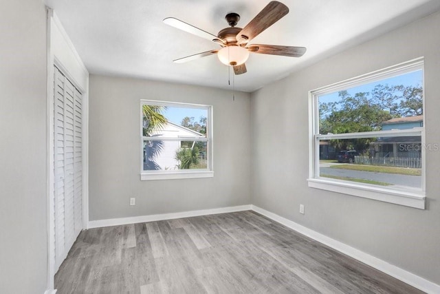 unfurnished room with light wood-type flooring and ceiling fan