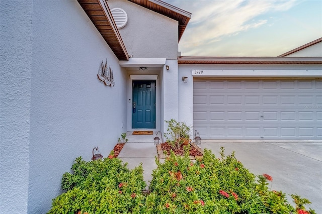 exterior entry at dusk featuring a garage