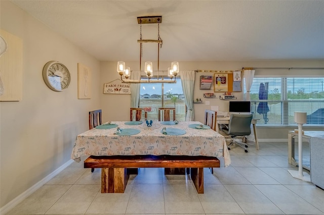 tiled dining room featuring a chandelier