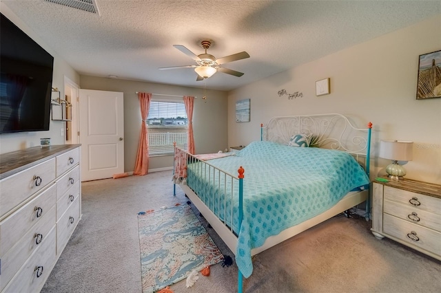 carpeted bedroom featuring a textured ceiling and ceiling fan