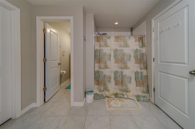 bathroom with tile patterned floors, a textured ceiling, and a shower with curtain