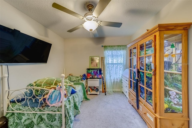 bedroom featuring a textured ceiling, ceiling fan, and light colored carpet