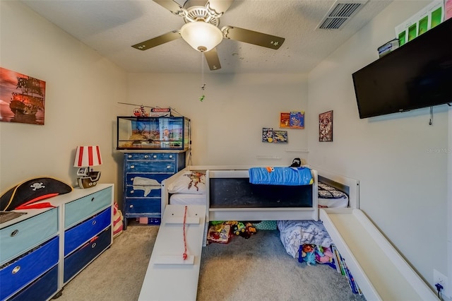 bedroom with a textured ceiling, ceiling fan, and light carpet