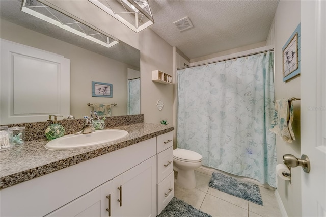 bathroom featuring toilet, tile patterned floors, vanity, and a textured ceiling