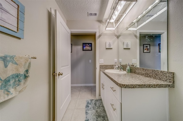 bathroom featuring vanity, tile patterned flooring, and a textured ceiling