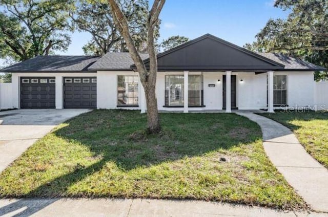 ranch-style house featuring a porch, a front lawn, and a garage