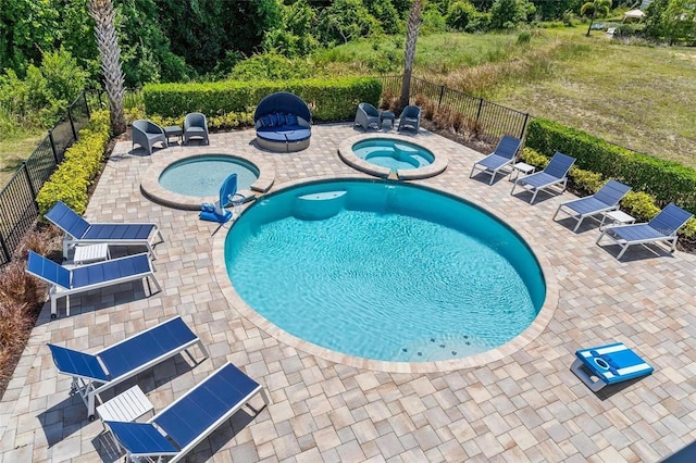 view of pool featuring a patio area and an in ground hot tub