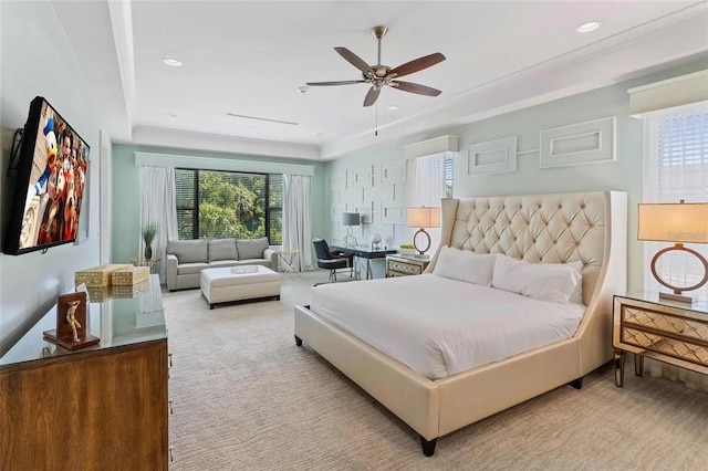 carpeted bedroom featuring a raised ceiling and ceiling fan