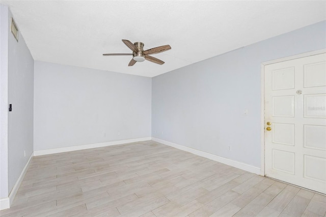 empty room with ceiling fan and light hardwood / wood-style flooring