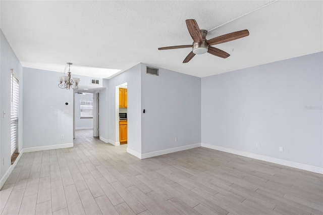 spare room with ceiling fan with notable chandelier, a textured ceiling, and light hardwood / wood-style floors