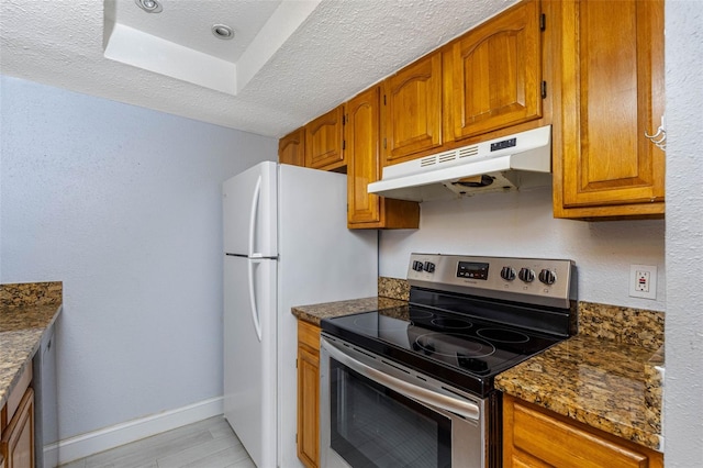 kitchen featuring stainless steel electric range, a textured ceiling, and dark stone countertops