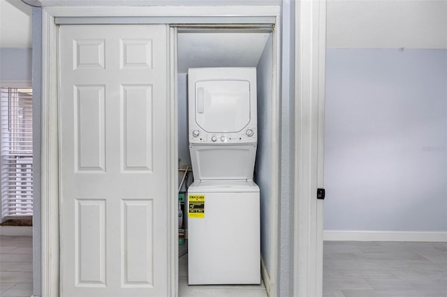 washroom with stacked washer and dryer and light wood-type flooring