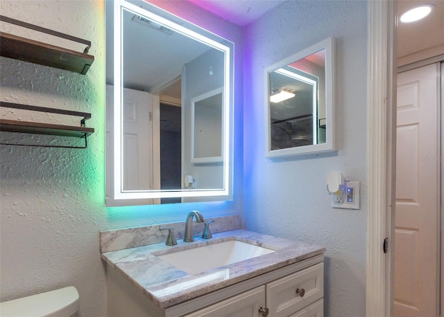 bathroom featuring vanity and toilet