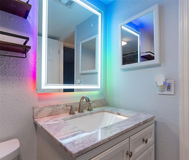 bathroom with toilet and vanity