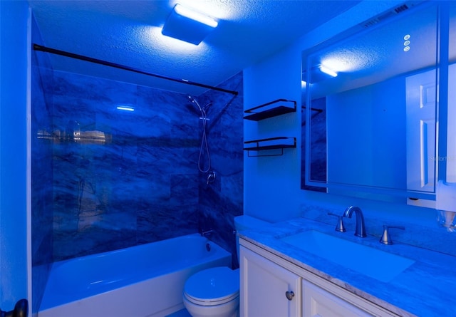 full bathroom featuring a textured ceiling, tiled shower / bath combo, vanity, and toilet