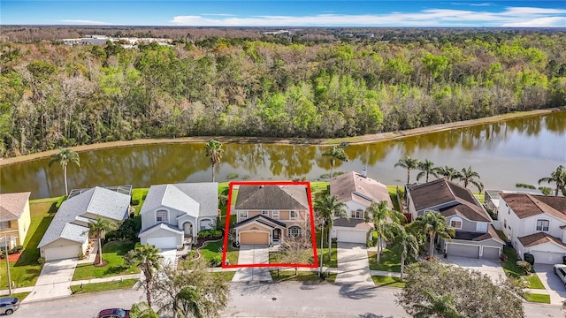 drone / aerial view with a residential view, a water view, and a view of trees