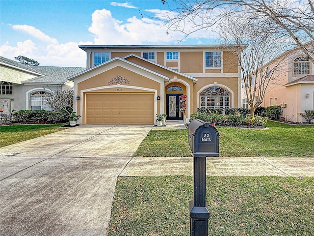 traditional home featuring a front yard, concrete driveway, an attached garage, and stucco siding