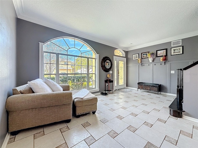 living room featuring visible vents, crown molding, a textured ceiling, and baseboards