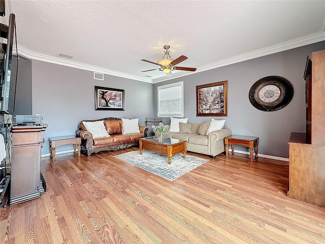 living area featuring ornamental molding, visible vents, a textured ceiling, and light wood finished floors