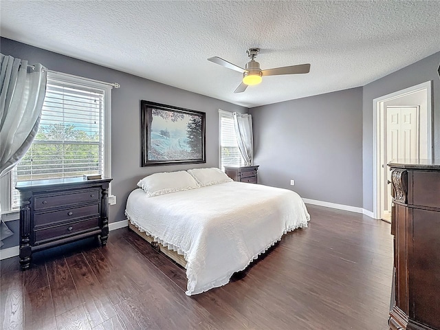 bedroom featuring dark wood-style floors, a textured ceiling, a ceiling fan, and baseboards