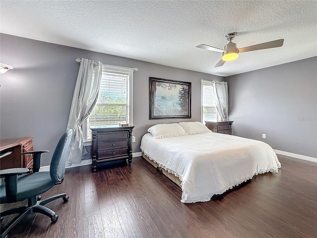 bedroom with dark wood finished floors, a textured ceiling, baseboards, and ceiling fan