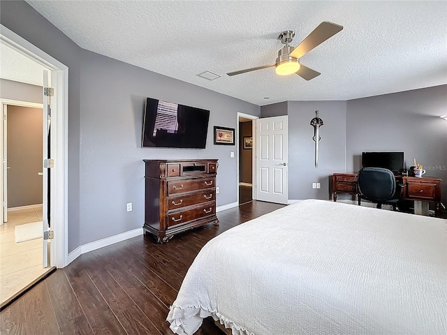 bedroom featuring baseboards, visible vents, ceiling fan, wood finished floors, and a textured ceiling