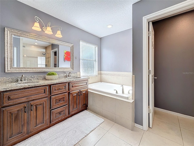 full bath with a textured ceiling, a sink, and tile patterned floors