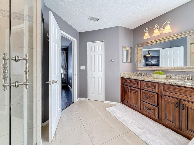 full bathroom with double vanity, visible vents, tile patterned floors, a textured ceiling, and a sink