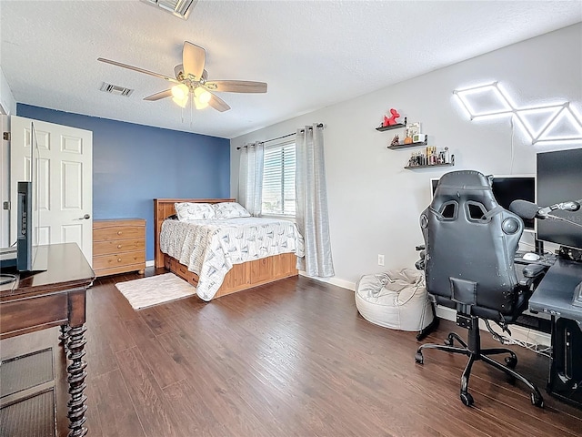 bedroom with a ceiling fan, a textured ceiling, visible vents, and wood finished floors