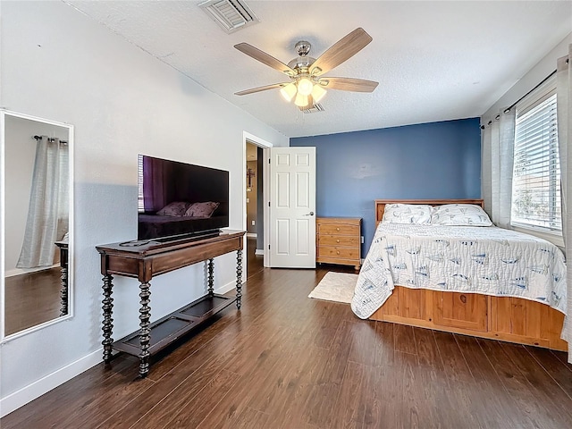 bedroom with visible vents, a ceiling fan, a textured ceiling, wood finished floors, and baseboards