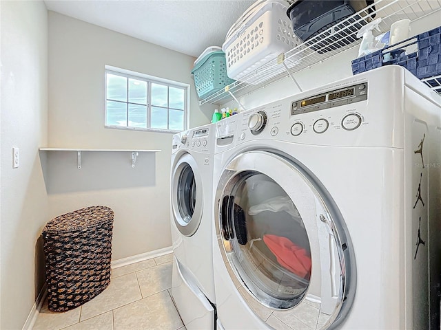 laundry room featuring laundry area, light tile patterned floors, baseboards, and washer and dryer