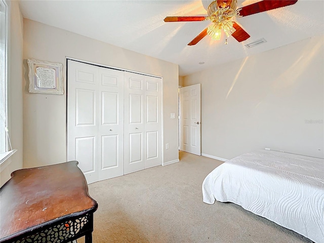 bedroom featuring carpet floors, a closet, visible vents, a ceiling fan, and baseboards